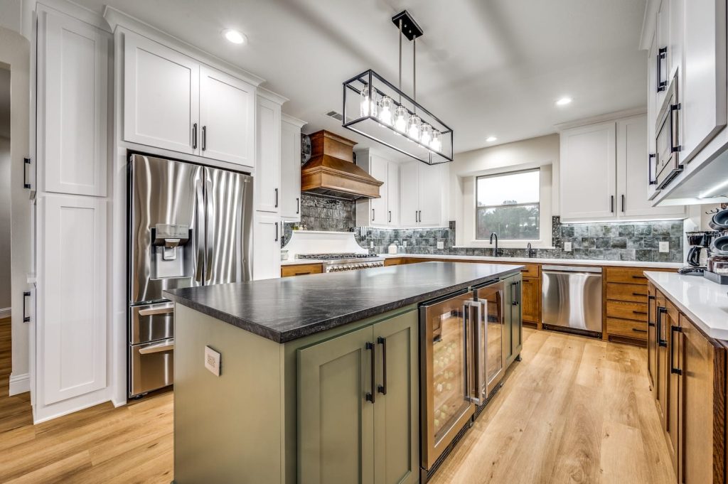 A beautiful kitchen with an island and new wood, stainless steel, and tile renovations.